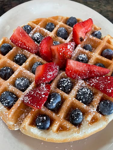 belgian waffle topped with blueberries and strawberries